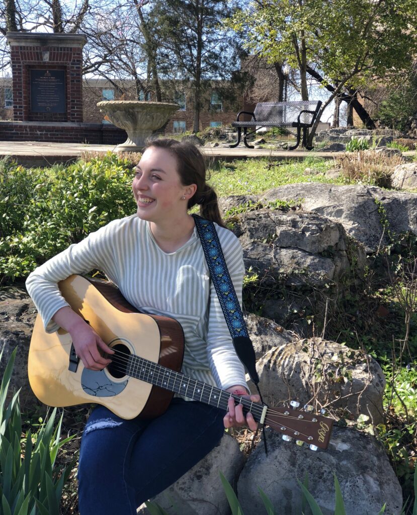 Natalie Renee playing guitar on Western Kentucky University's campus