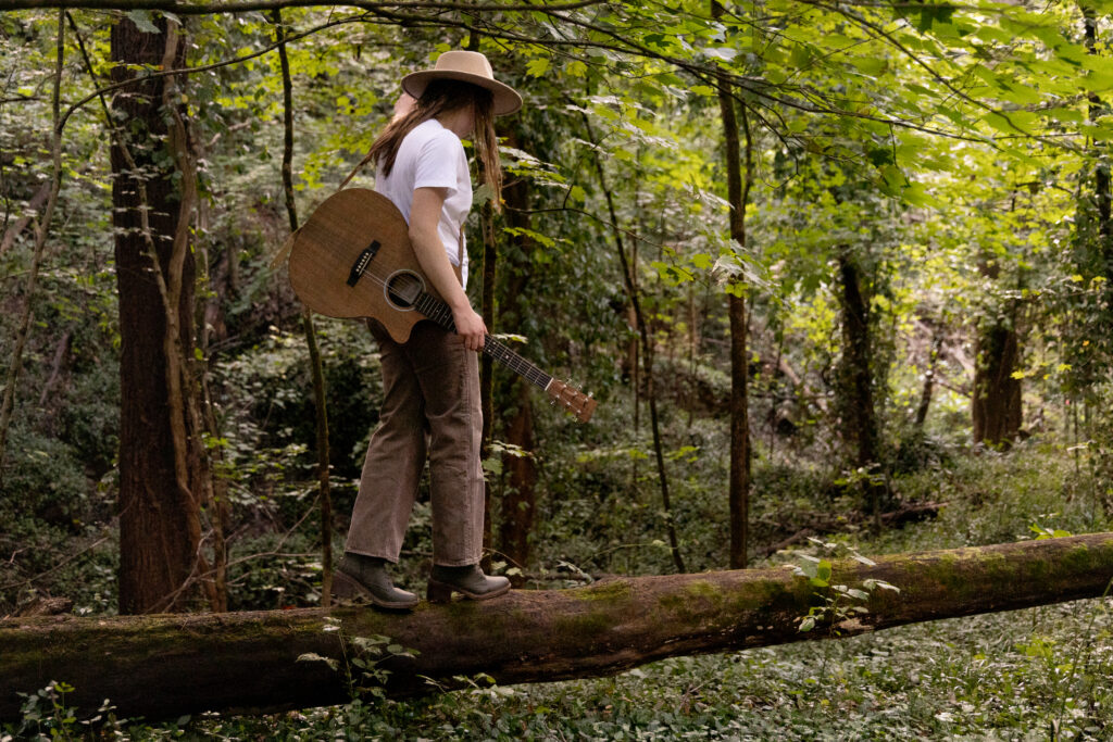 Natalie Renee walking on a log in the woods; cover image for the official lyric video of "Done Holding On."